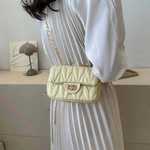 Quilted beige shoulder bag with gold chain strap and elegant metallic twist lock closure