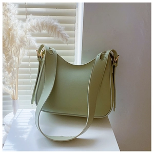 Detail of light green minimalist hobo bag with smooth texture and gold metal buckle
