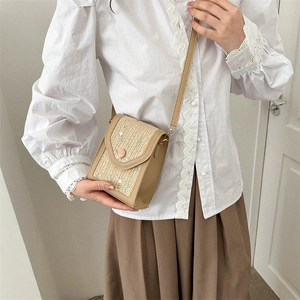 Woven straw crossbody bag with floral embroidery and adjustable leather strap