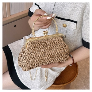 Detail of hand-woven straw bag with carved gold metal handle and vintage clasp
