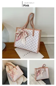 Detail of large monogram tote bag with pink leather trim and decorative silk scarf