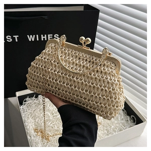 Detail of cream handmade woven clutch with gold metal handle and chain strap for parties