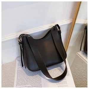 Détail d'un sac bandoulière en similicuir mat noir avec une large sangle et une boucle réglable