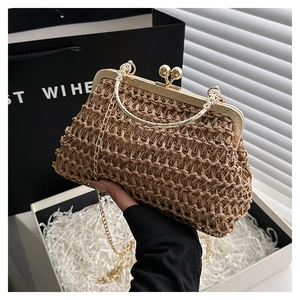Close-up of handmade straw bag featuring golden sphere clasp and metallic ring handle