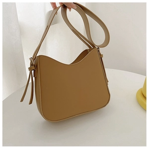Détail du sac à épaule en cuir camel en forme de U avec texture lisse et lanières