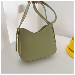 Détail d'un sac hobo vert avocat avec bandoulière réglable et pompon décoratif