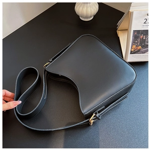 Détail du sac à bandoulière demi-lune noir mat minimaliste avec boucle dorée