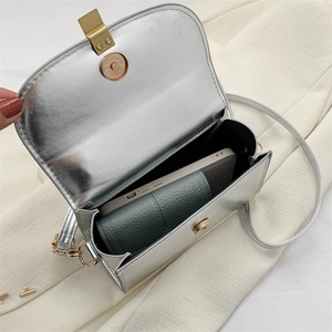 Silver metallic crossbody bag with magnetic flap showing internal phone and wallet capacity