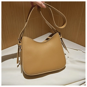Détail du sac à bandoulière en similicuir caramel avec texture et sangle réglable