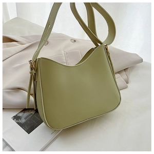 Détail du sac à bandoulière en cuir vert avocat avec boucles dorées et forme courbée