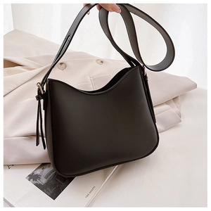 Détail du sac à épaule en cuir noir mat avec lacets latéraux et ouverture courbée