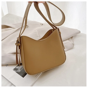 Détail du sac bandoulière camel avec lacets latéraux et finition en cuir mat