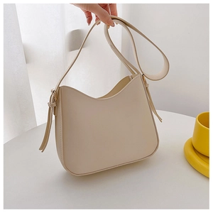 Vue détaillée du sac hobo crème montrant sa texture lisse et sa longue bandoulière