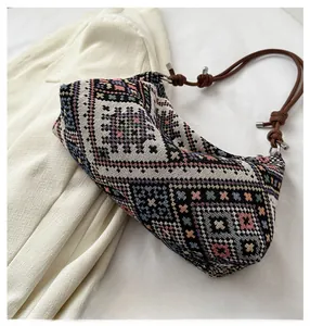 Close-up of ethnic woven shoulder bag showing geometric patterns and brown leather strap