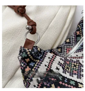 Detail of ethnic woven shoulder bag with geometric patterns and brown leather strap