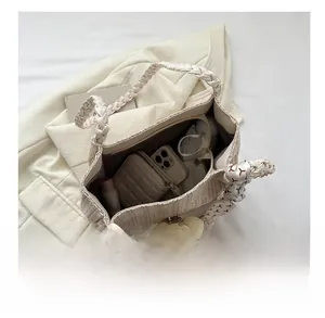 Vue détaillée de l'intérieur spacieux du sac cabas tissé beige pour les essentiels