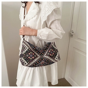 Close-up of geometric woven fabric texture on a blue ethnic shoulder bag for women