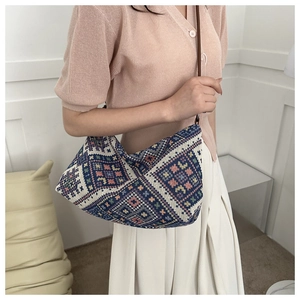 Ethnic geometric pattern fabric shoulder bag with brown leather strap shown on shoulder