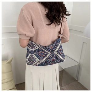 Ethnic geometric pattern shoulder bag with brown leather strap worn by a model