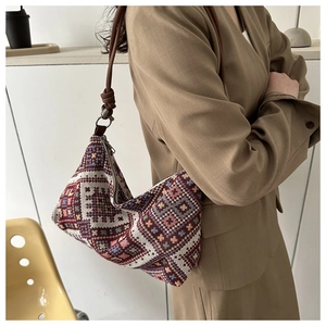 Detail of retro ethnic patterns and woven texture on a blue shoulder handbag for women