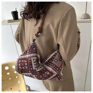 Ethnic geometric pattern hobo bag worn by a model in a cozy cafe lifestyle setting