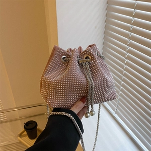 Detailed shot of pink bucket bag with silver rivets and pearl drawstring accents