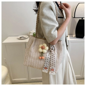 Détail du sac cabas tissé avec texture en V, pendentif orange et foulard en soie décoratif