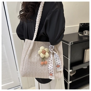 Détail du sac cabas tissé crème avec pendentif fleur 3D et accessoire foulard en soie