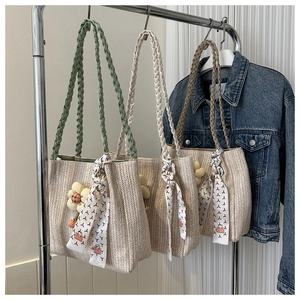 Détail de sacs fourre-tout en paille tressée avec fleurs et poignées colorées