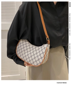 Detail of vintage canvas hobo bag with clover pattern and brown leather straps
