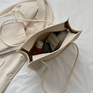 Large beige woven straw tote bag with zipper closure and gold chain detail