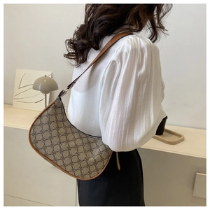 Lifestyle shot of a vintage crescent shoulder bag with floral print and leather trim