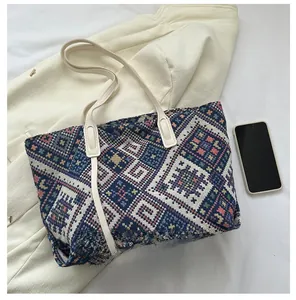 Detailed comparison of geometric canvas tote bag next to a smartphone for size reference