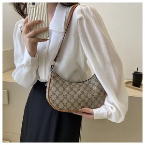 Retro monogram crescent shoulder bag in brown leather trim worn by a model