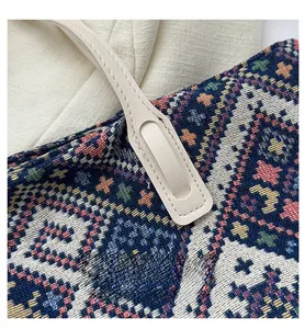 Detail of colorful geometric woven canvas tote with cream leather handle stitching