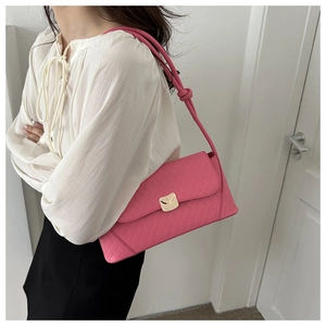 Detail of hot pink quilted baguette bag with gold metal buckle and knotted shoulder strap