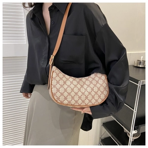 Fashionable hobo crescent bag with vintage pattern and brown leather trim on female model