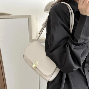 Chic off-white leather underarm bag with gold metal twist lock and knot detail strap