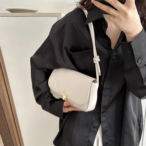 Retro cream-white underarm bag with a gold buckle and knotted strap on a model
