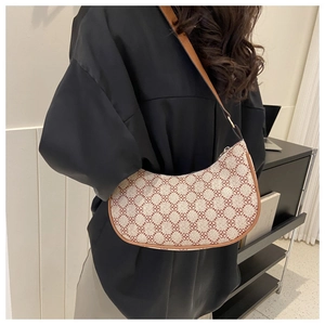 Detail of vintage canvas hobo bag featuring geometric floral patterns and brown leather trim