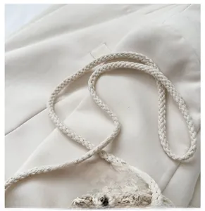Detailed macro view of a creamy white woven cotton rope strap for a summer straw bag