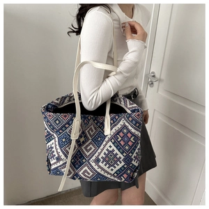 Close-up of bohemian geometric woven tote bag with durable cream shoulder straps