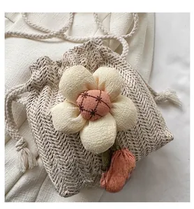 Detailed close-up of a mini straw bucket bag with 3D flower and red cherry pendant