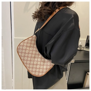 Detailed view of the brown geometric clover pattern on a crescent-shaped hobo shoulder bag