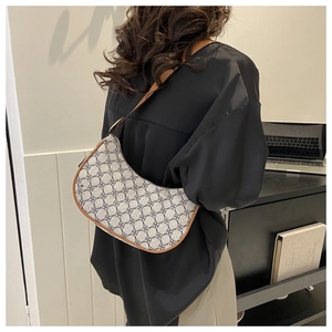Detailed side view of vintage patterned hobo bag worn on shoulder for commuting