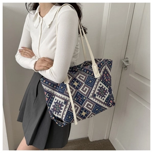 Ethnic geometric canvas tote bag featuring navy and red woven patterns with leather strap