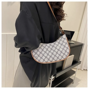 Detail of vintage clover pattern hobo bag with brown leather trim and shoulder strap