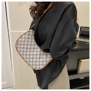 Side view of retro crescent moon bag with floral patterns and leather straps on model