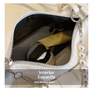 Macro shot showing internal capacity of the white bag with pearl chain details