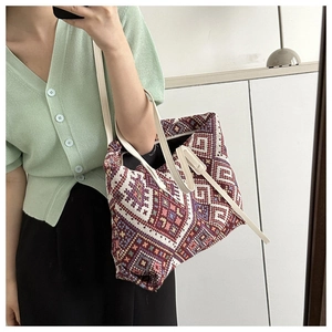 Ethnic geometric jacquard tote bag detail featuring red and white patterns and leather straps